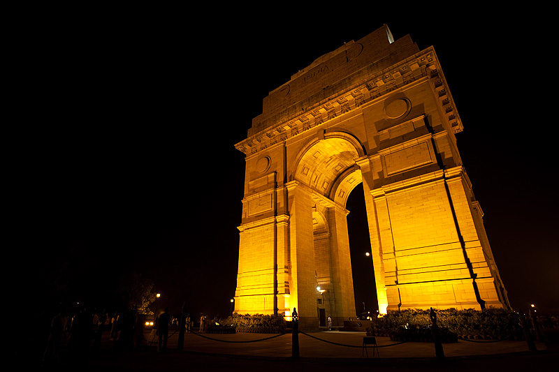 India Gate, memorial for fallen Indian soldiers lighted at night with the rising moon through its legs. - Delhi, India - Daily Travel Photos