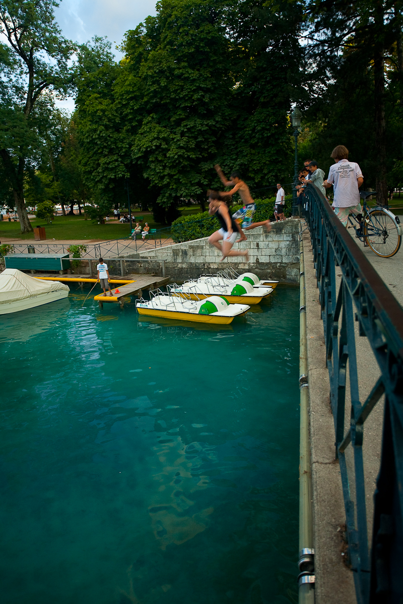 French children jump from a bridge into beautiful lake Annecy - Annecy, France - Daily Travel Photos