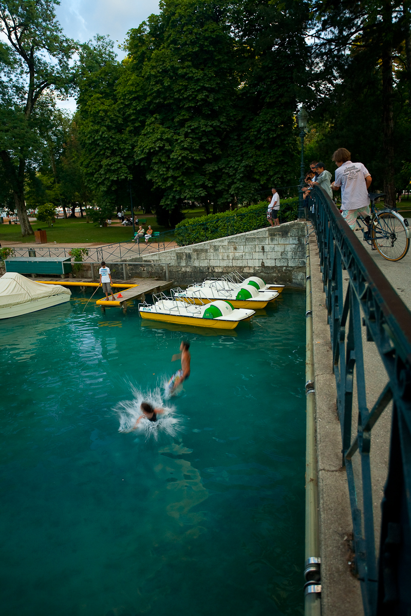 French children jump from a bridge into beautiful lake Annecy - Annecy, France - Daily Travel Photos