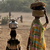 Village Life Photo: Mother and daughter balance pots on their heads to collect water at the village water tank.