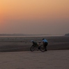 Mekong River Bicyclists Photo: A Laotian bicyclist pauses to take in the sunset over the Mekong River in Vientiane, Laos.