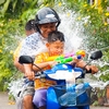 Songkran Festival, Thai New Year Photo: A direct hit lands on a motorcycling Dad and his unprotected kids during Songkran water fights.