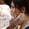 Songkran Pasted People Photo: A young Thai woman receives a gentle application of talcum powder paste from a stranger during Songkran.