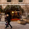 Seasonal Sentiment Photo: Shoppers visit Christmas-theme decorated stores on a shopping street in old Annecy.