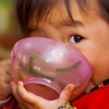 photo: Dubious Deadeye - A young Chinese girl plants her face in her food bowl while keeping a wary eye on the photographer (ARCHIVED PHOTO on the weekends - originally photographed 2007/09/30).